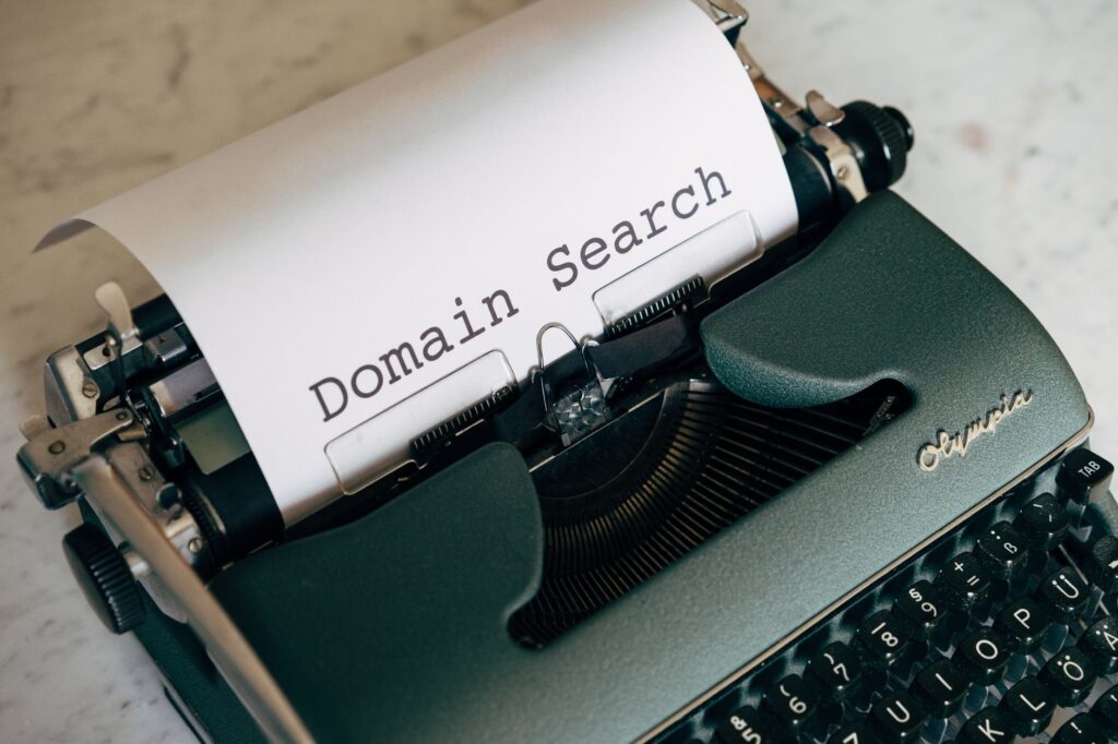 Close-up of a vintage typewriter with paper displaying 'Domain Search' text, ideal for retro themes.