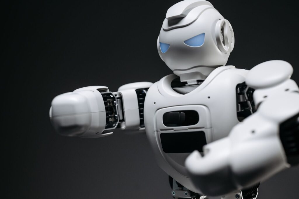 Detailed close-up of a high-tech white robot in a studio setting with a gray background.