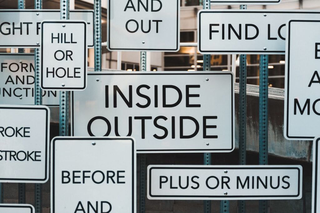 A creative display of street signs in Salt Lake City, showcasing contrasting messages and typography.