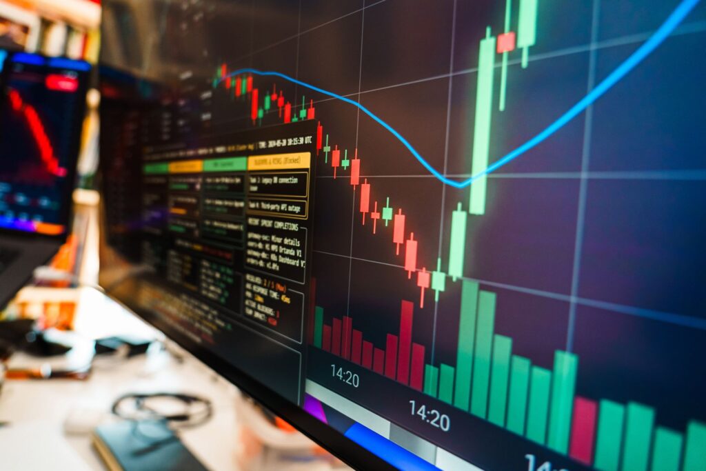 Close-up of a financial monitor displaying real-time cryptocurrency data and charts in a modern office.