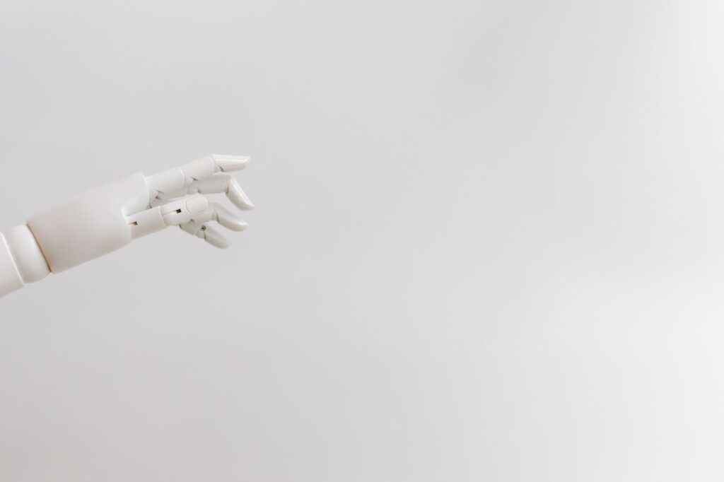 Minimalist image of a robotic hand reaching out on a white background.